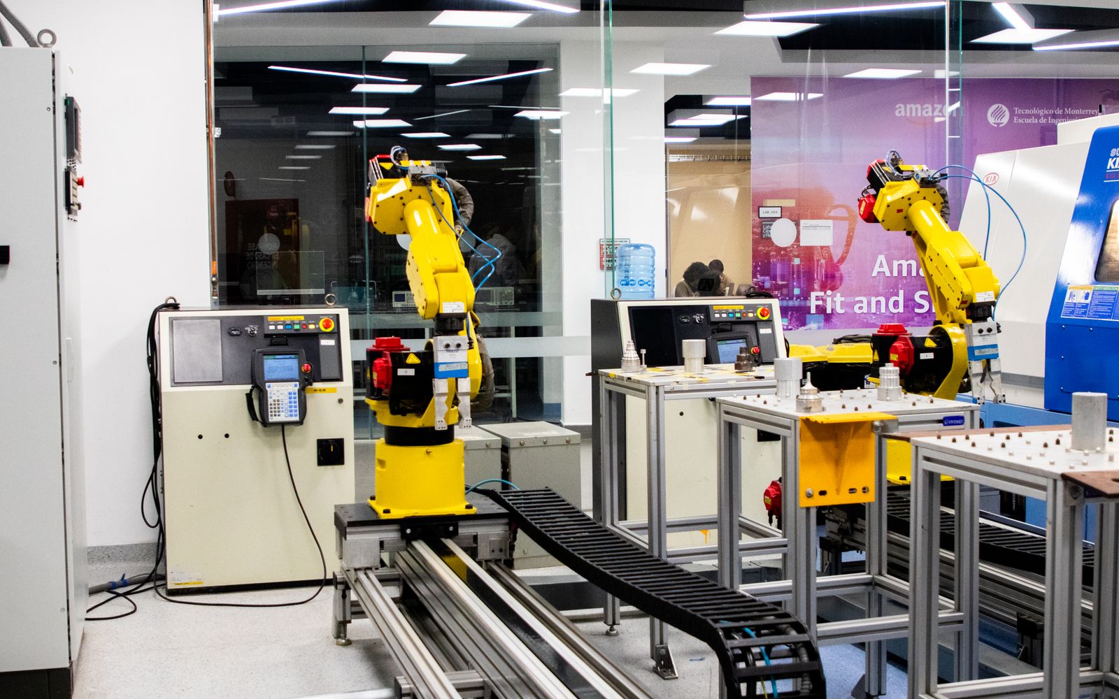 Robotic arms in action within a modern industrial control room setting, showcasing technology and production.
