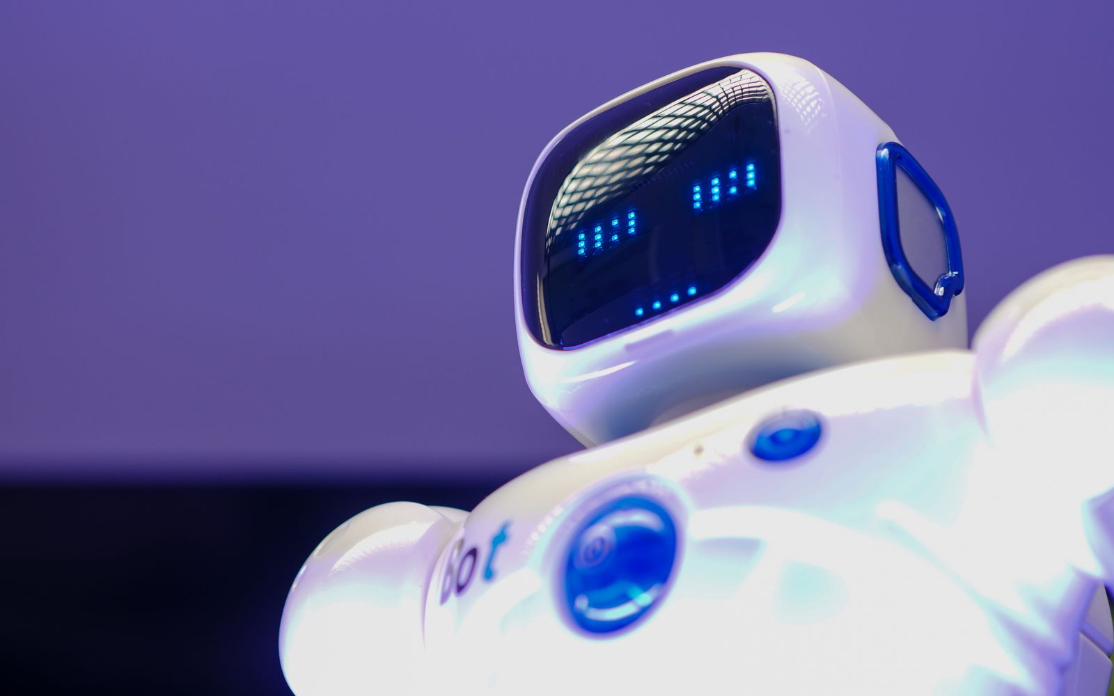 A modern humanoid robot with digital face and luminescent screen, symbolizing innovation in technology.