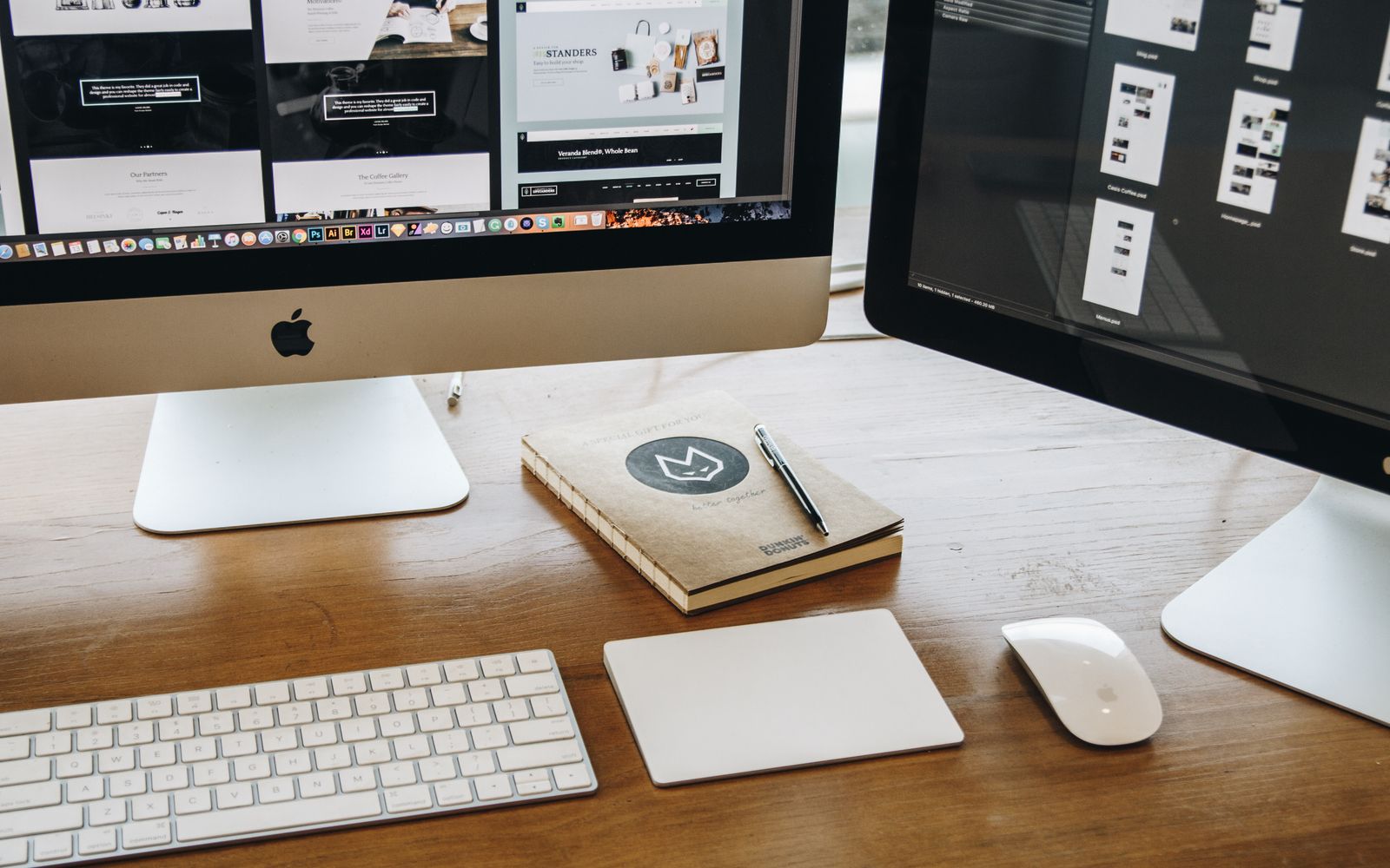 A minimalist desk setup featuring dual monitors, keyboard, mouse, and notebook for productivity.
